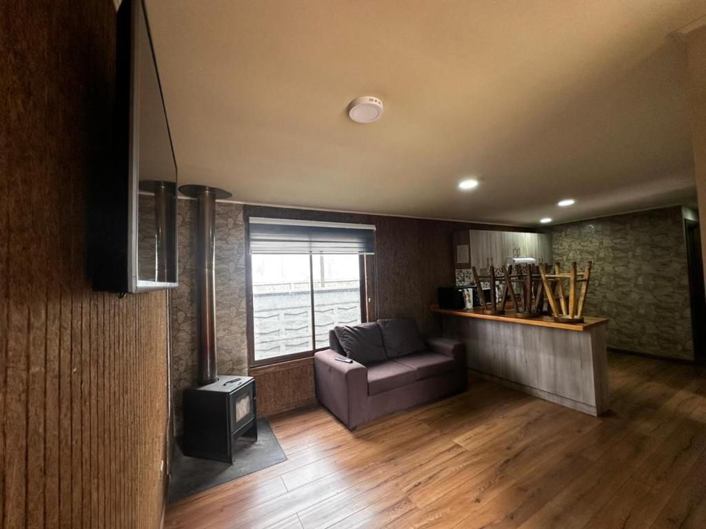 a living room with a couch and a window at Cabañas y hospedaje kalú in Nueva Imperial