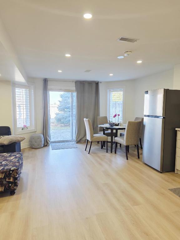 a kitchen and dining room with a table and a refrigerator at 2 Bed, 1 Bath- Main floor, 2 Parking- Licensed in Oakville