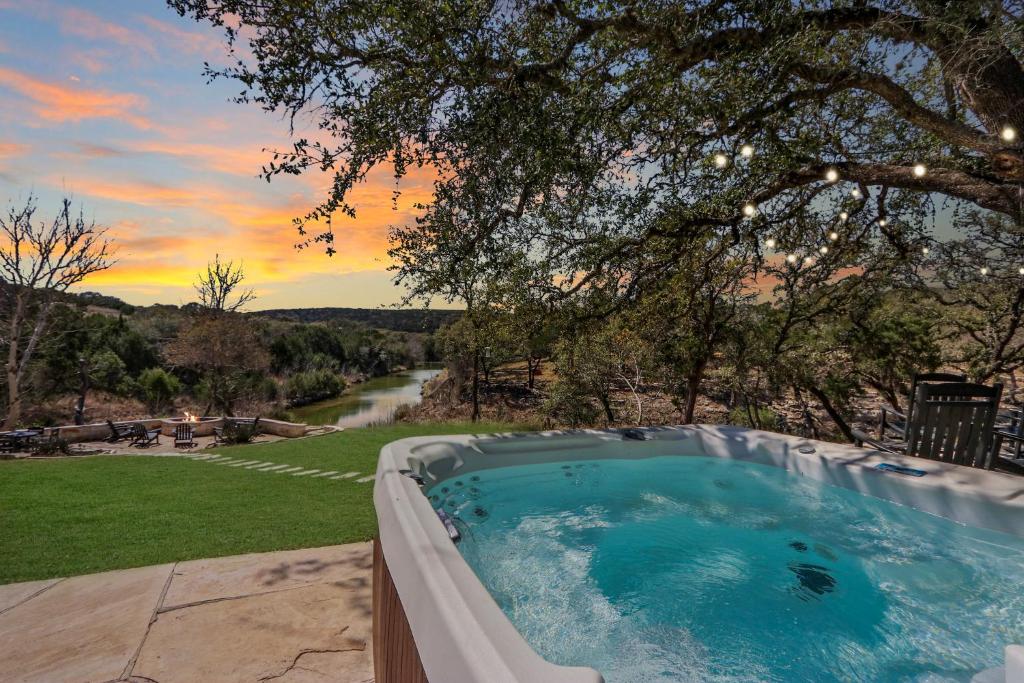 a hot tub in a yard with a tree at 2 Creeks in Wimberley