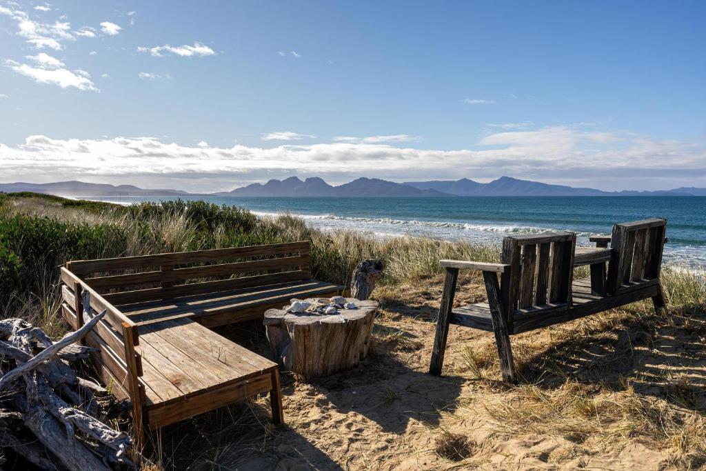 two benches and a table on the beach at The Dunes Hideaway in Dolphin Sands
