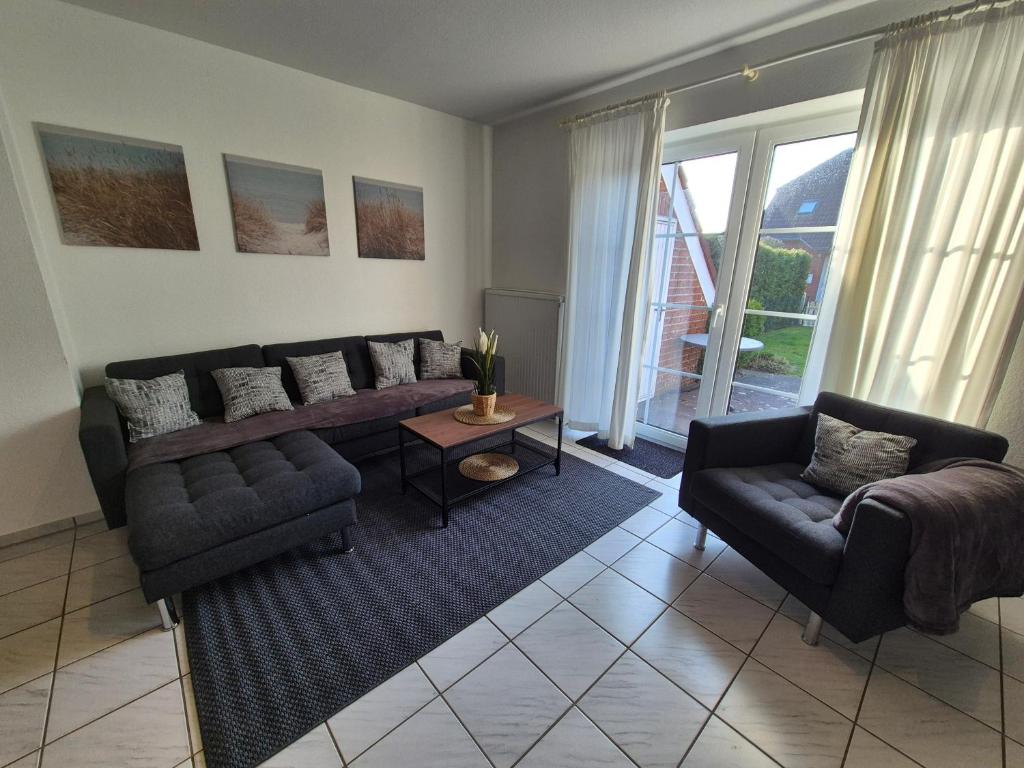 a living room with a couch and a table at Ferienhaus Wattgeflüster Neßmersiel in Neßmersiel