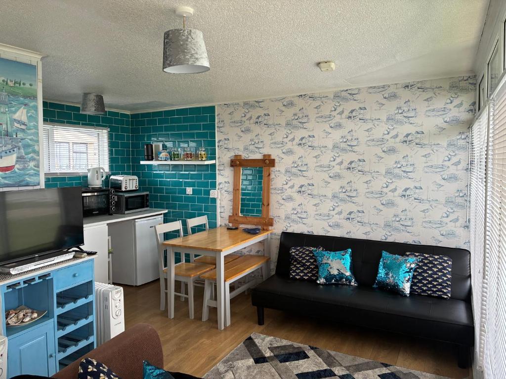 a living room with a couch and a table at Chalet 65 in Chapel Saint Leonards