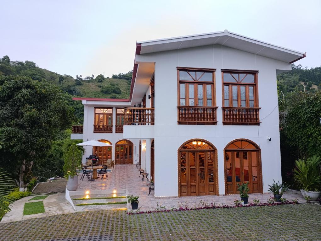 a white house with a patio in front of it at Casa Colonial Maria Elena in Pereira