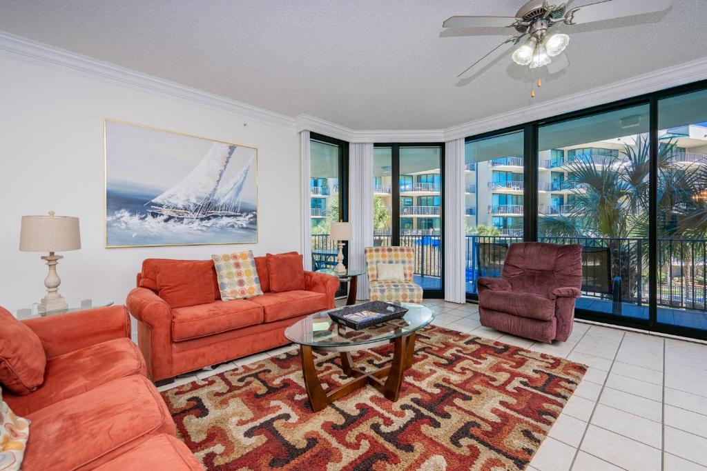 a living room with a couch and chairs and a table at Phoenix on the Bay 1213 in Orange Beach