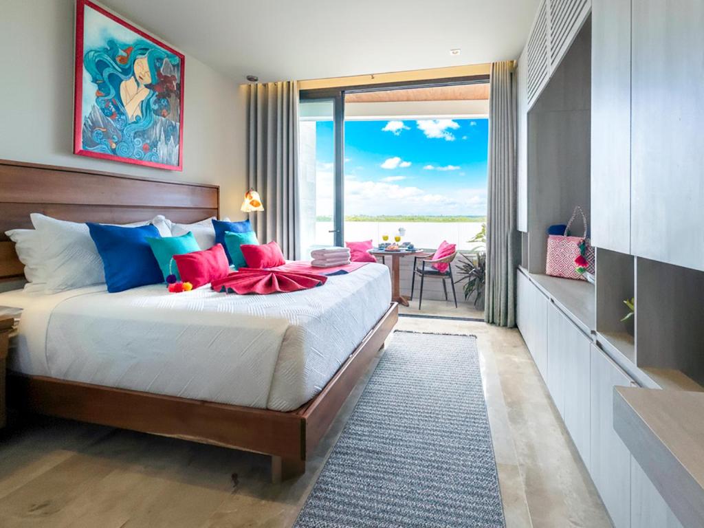 a bedroom with a bed with a view of the ocean at Casa La Aurora - Beachfront Studio and Rooftop Infinity Pool in Puerto Morelos