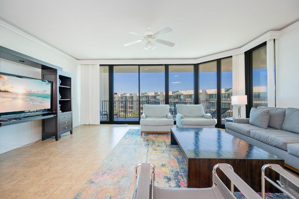 a living room with a couch and a tv at Phoenix on the Bay 1528 in Orange Beach