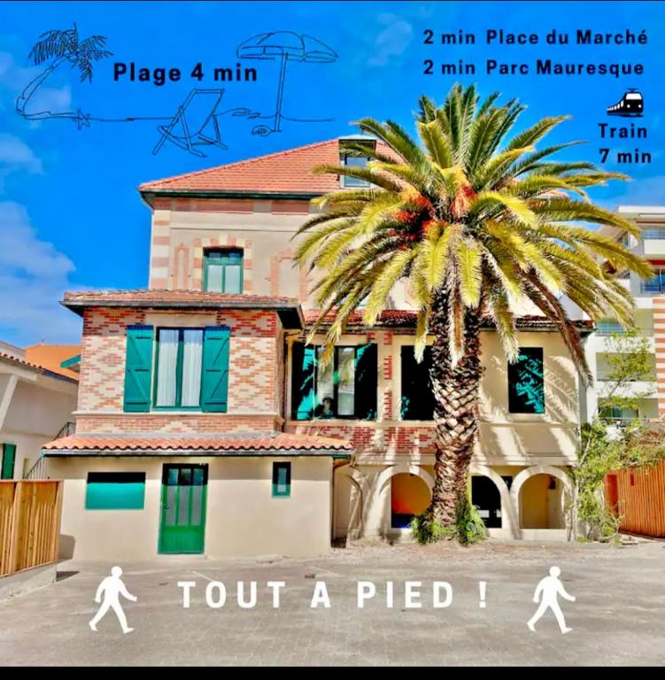 two people walking in front of a building with a palm tree at Parenthèse en Ville in Arcachon