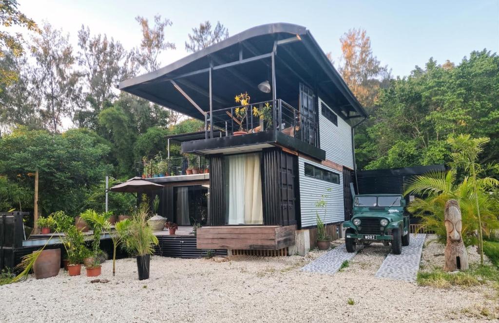 a house with a black roof on a beach at Tiny Black Loft in Port Vila
