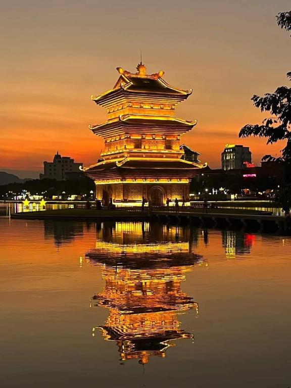 a large tower in the water at sunset at Bich Gian Trang An Hostel in Nguyên Ngoại