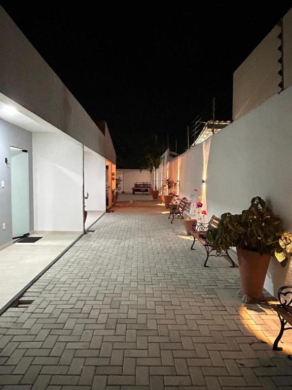 an empty hallway with benches on a building at night at Pousada Aconchego Mineiro in Aracaju