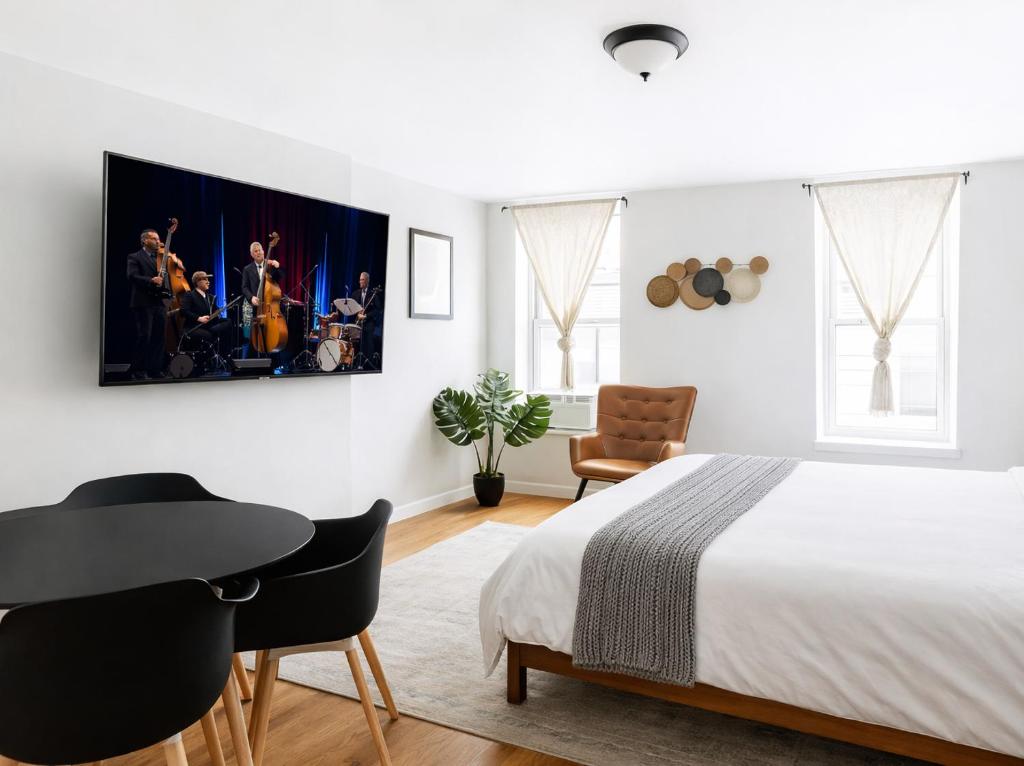 a bedroom with a bed and a table and a desk at Hoboken Studio 15 Min from Manhattan in Hoboken
