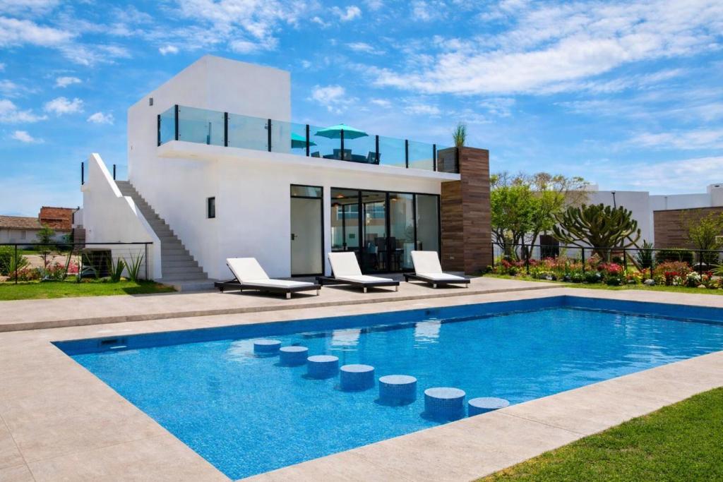 a villa with a swimming pool in front of a house at Casa en Paseo San Junipero in San José el Alto