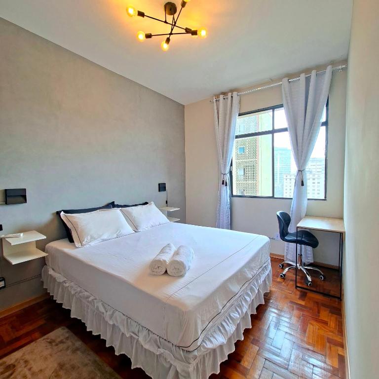 a bedroom with a bed with two towels on it at Centro de BH, Ar-Condicionado, Wi-Fi Rápido, 6min Rodoviária, Portaria 24h in Belo Horizonte