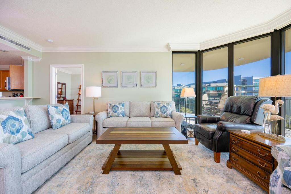 a living room with a couch and a table at Phoenix on the Bay 1405 in Orange Beach