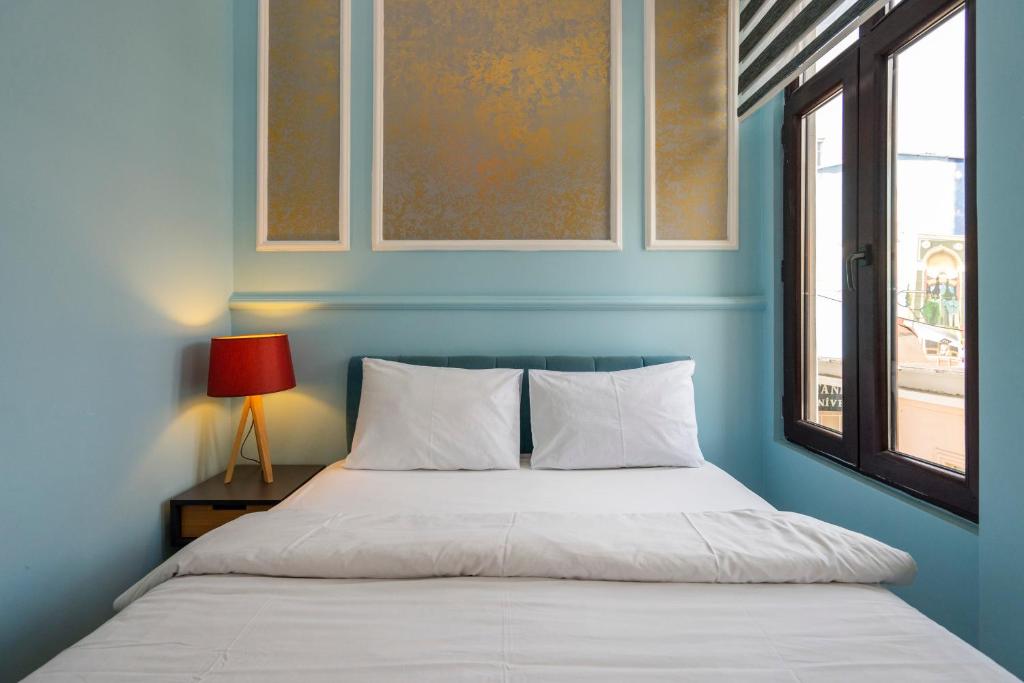 ein blaues Schlafzimmer mit einem Bett und einem Fenster in der Unterkunft cool cihangir in Istanbul