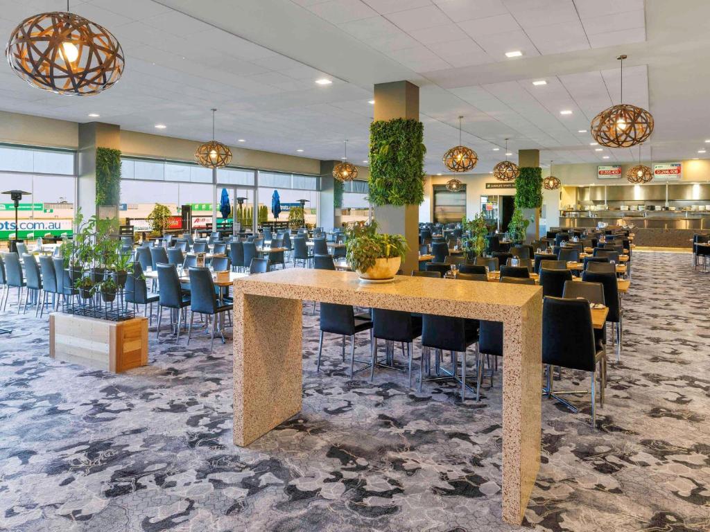 a lobby with a large table and chairs at Mantra Melbourne Melton in Melton