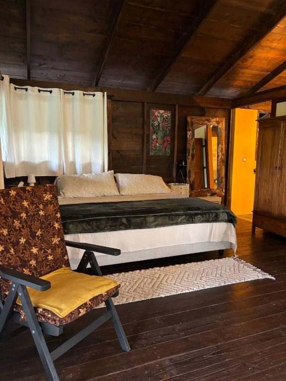 a bedroom with a large bed and a chair at My Mountain Home - Le Chalet in Afaahiti