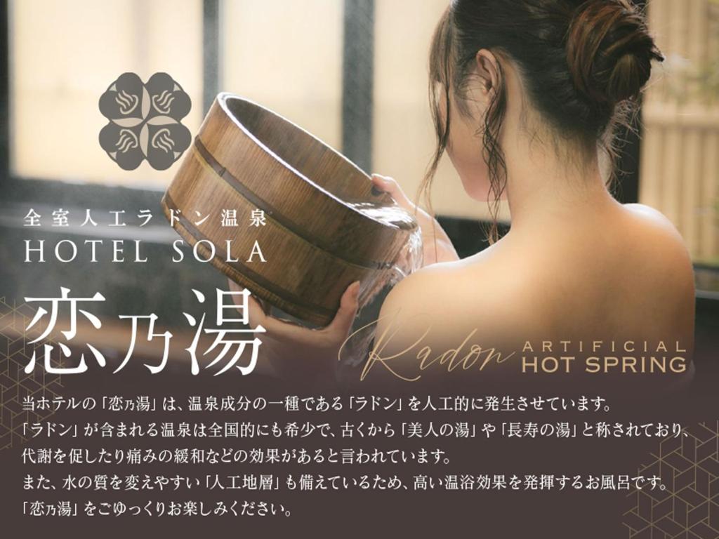 Eine Frau hält ein Buch vor ein Fenster. in der Unterkunft HOTEL SOLA Yame-ADULT ONLY-artificial hot spring- in Chikugo