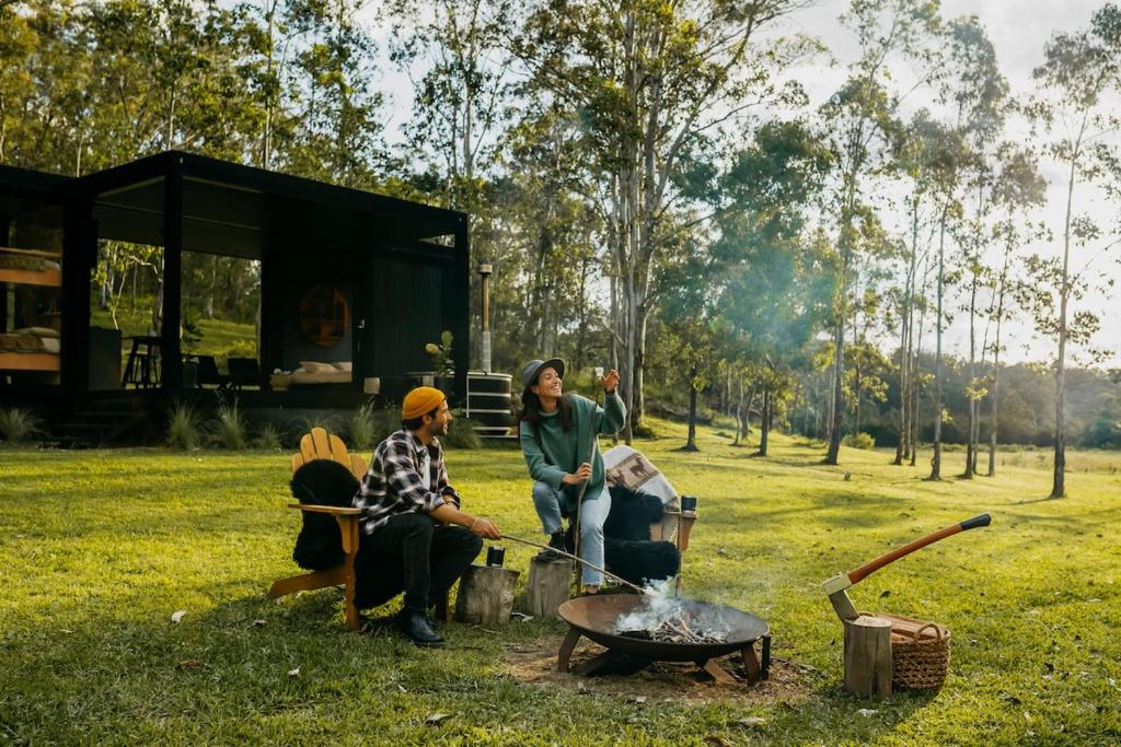 a group of people sitting around a fire in a field at The Lookout - a Huch experience in Wollombi