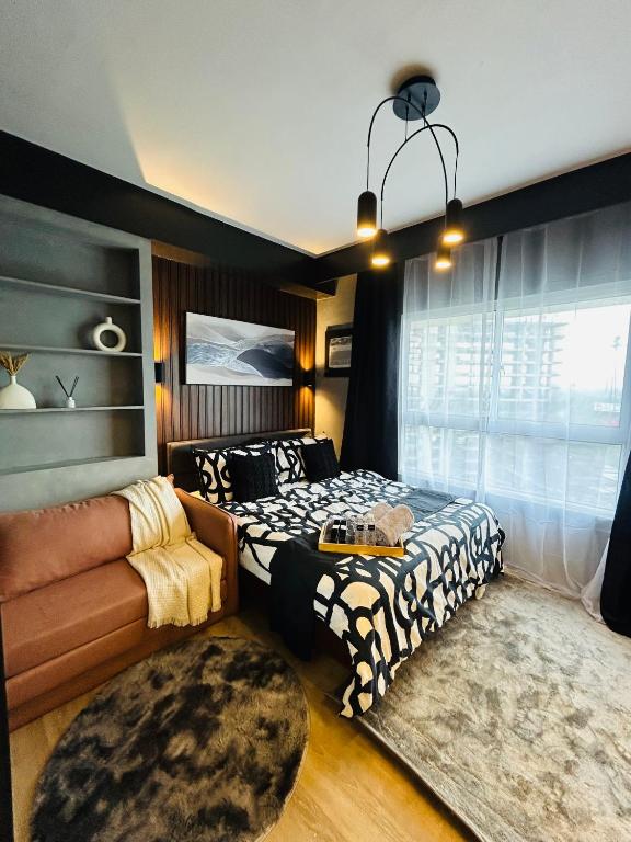 ein Schlafzimmer mit einem Bett und einer Couch in der Unterkunft Sten Haven Suite in Bacolod City
