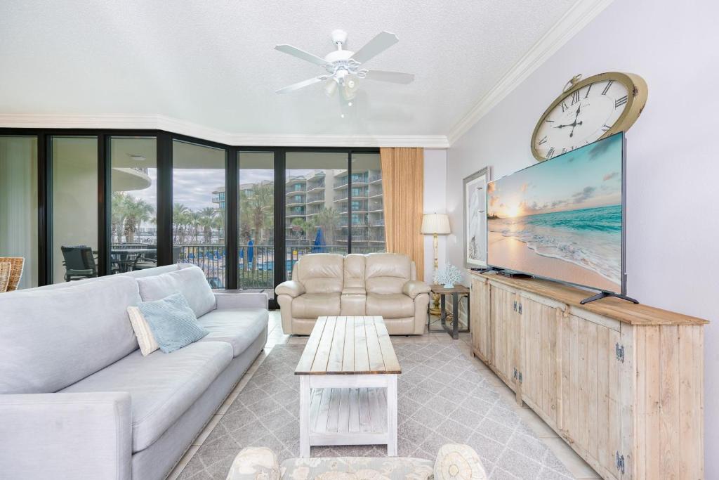 a living room with a couch and a large screen tv at Phoenix on the Bay 1129 condo in Orange Beach