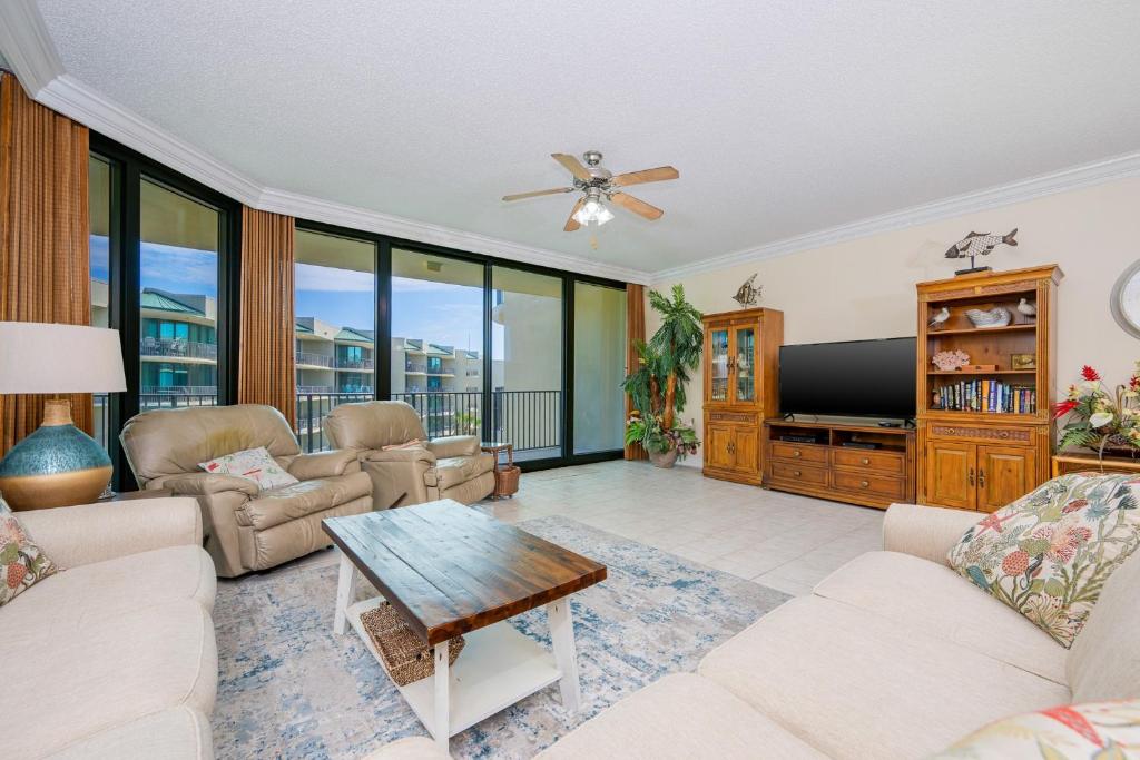a living room with a couch and a tv at Phoenix on the Bay 1415 in Orange Beach