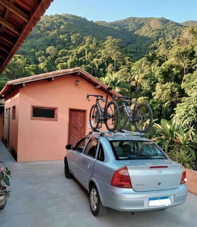 a car parked in front of a house with a bike on top at Chalé das águas in Cunha