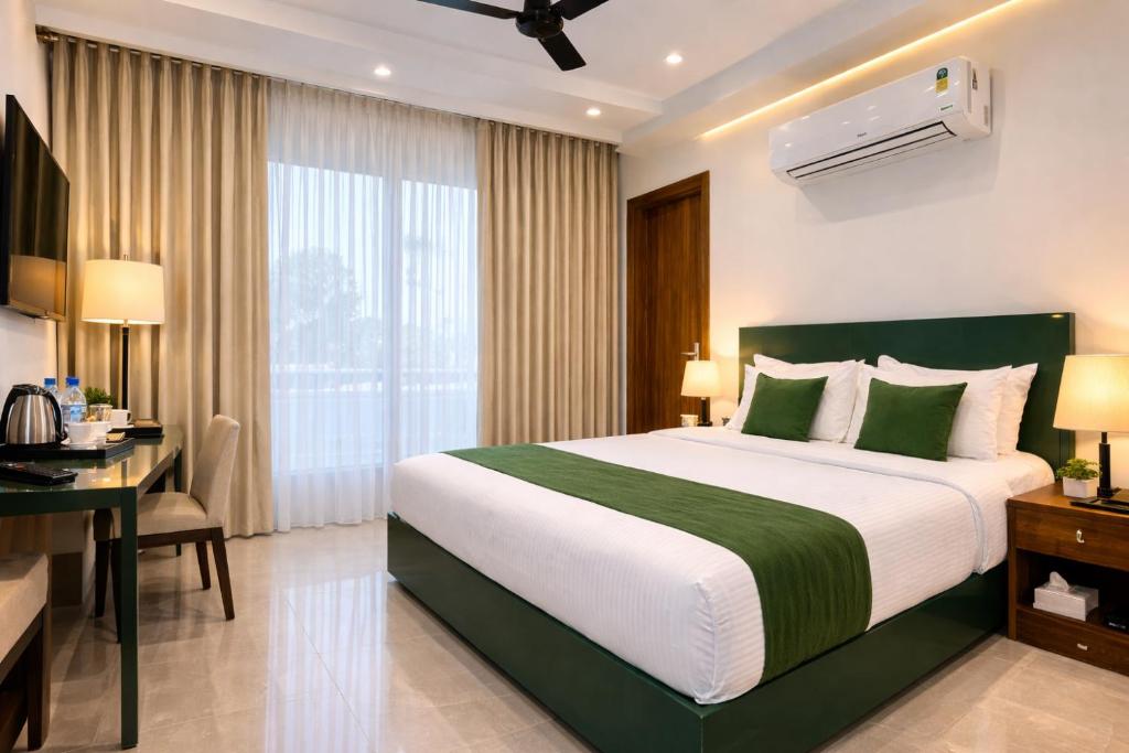 a hotel room with a large bed and a desk at Skytouch Residency-OMR in Chennai