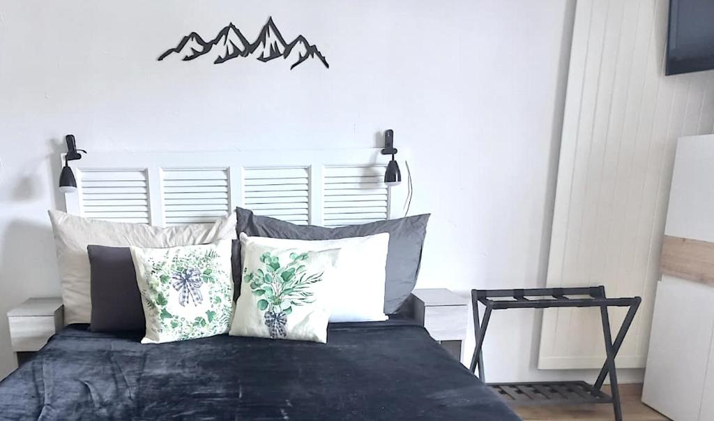a bedroom with a bed with mountains on the wall at Charming Studio - Ferienwohnung - Vulpera, Scuol in Scuol