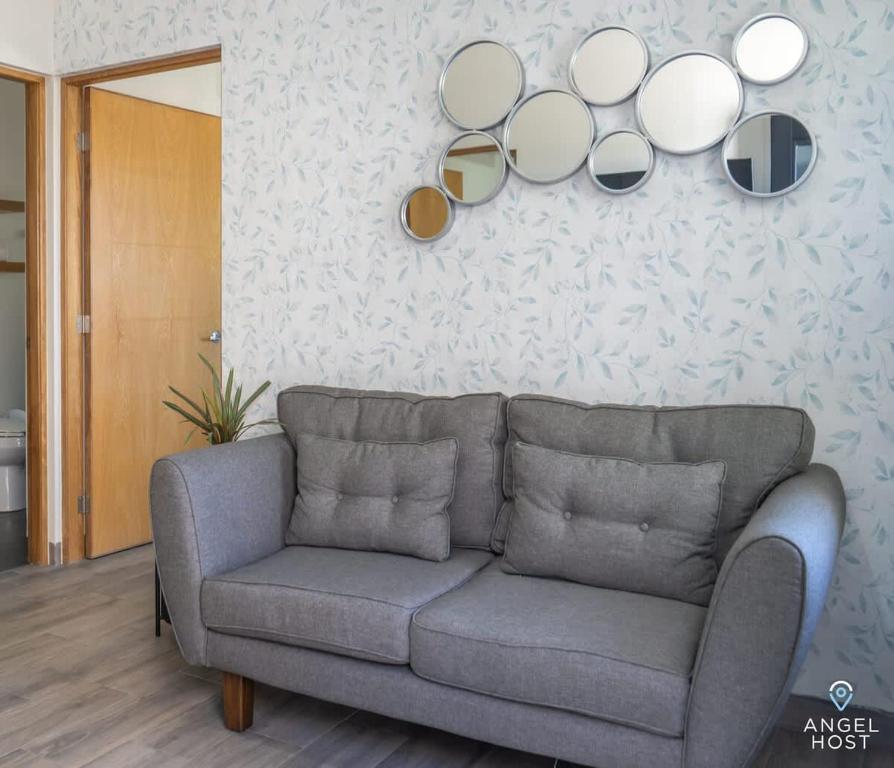 a living room with a couch and mirrors on the wall at Pool BBQ & a Short Walk to the Malecon in La Paz