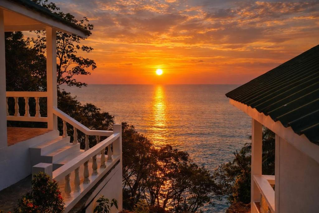 a sunset from the balcony of a house at Private Paradise Resort in Ko Chang