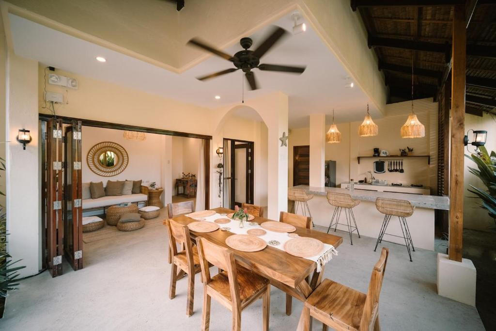 a dining room and kitchen with a table and chairs at Villa Ramira in General Luna