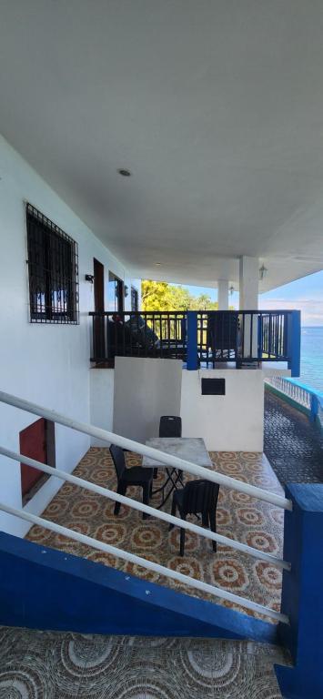 a room with a balcony with a table and a table at Sandra's holiday house in Oslob