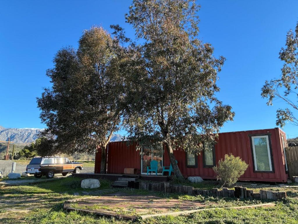 a red tiny house with a tree in the yard at Private Ranch Retreat in Banning