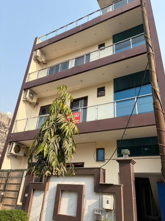 a building with a palm tree in front of it at PLAY HOTEL BLU MOON couple friendly in Greater Noida