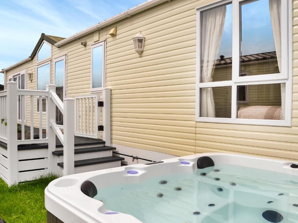 a hot tub in front of a house at Lavender Lodge in Patrington