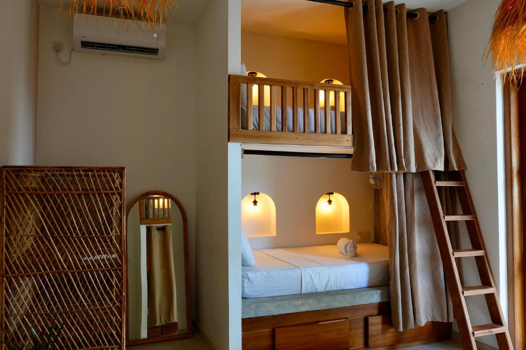 a bedroom with a bunk bed with a ladder and a mirror at Dreamers Surf House in Matara