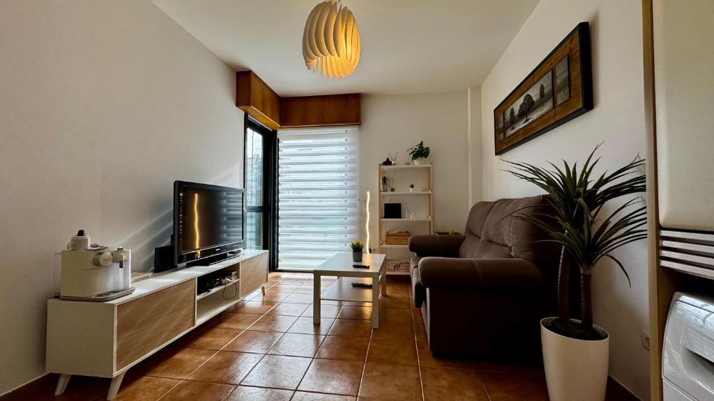 a living room with a couch and a tv at PLAYA Finisterre in Fisterra