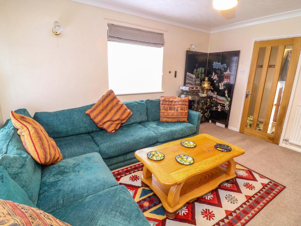 a living room with a blue couch and a coffee table at 5 Overstone Drive in Wisbech
