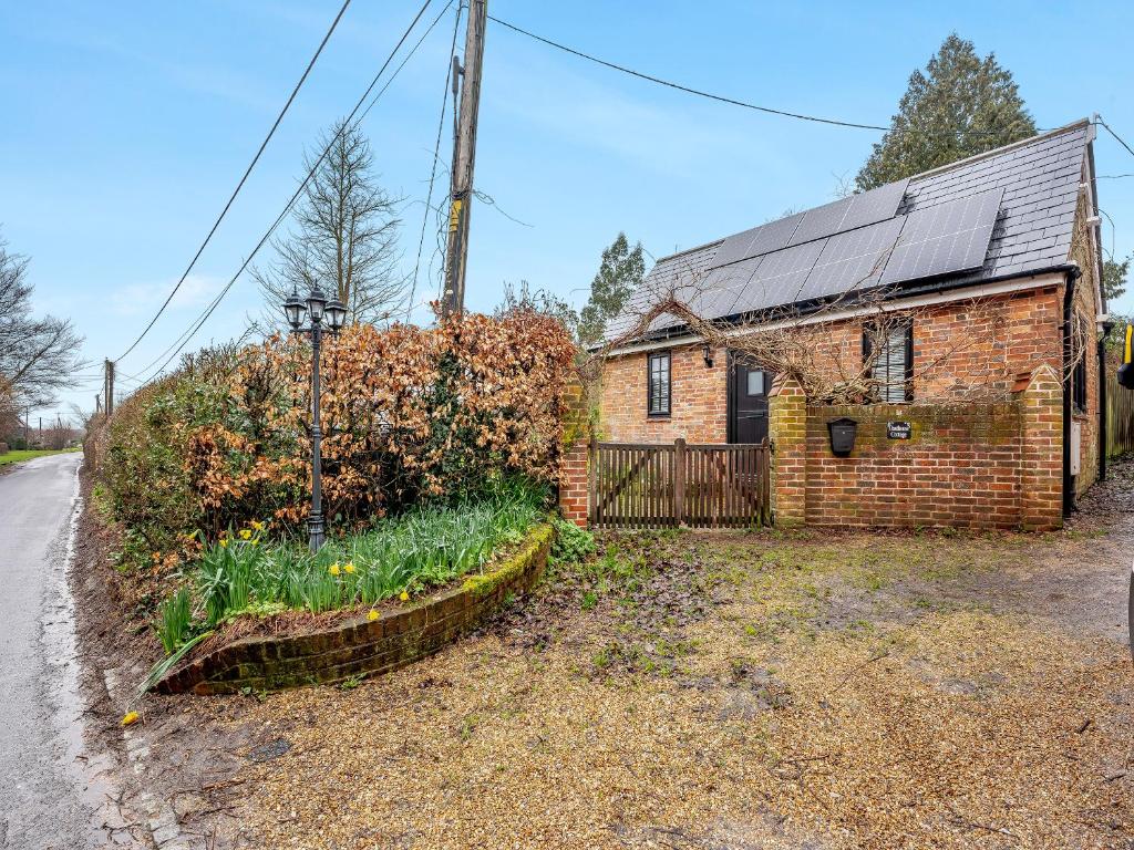 an old brick house with a garden in front of it at Wisteria Cottage in Heathfield