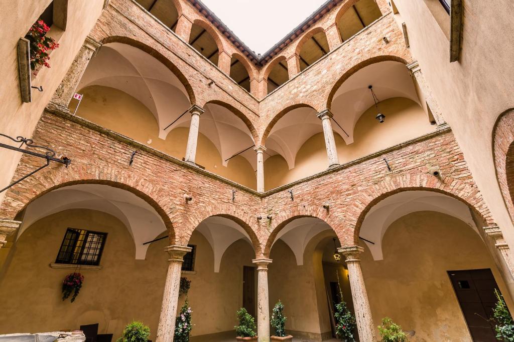 an arcade of a building with arches at Appartamenti Bellarmino in Montepulciano