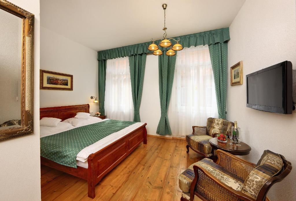 a bedroom with a bed and a flat screen tv at Pension Rozmarýna in Český Krumlov