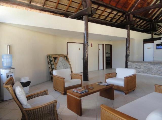 uma sala de estar com cadeiras e uma mesa em Flat Nannai Residence Muro Alto Terreo Frente Piscina em Porto de Galinhas