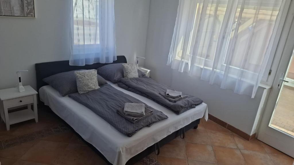 a bedroom with a bed with blue sheets and pillows at David Apartman in Gyula