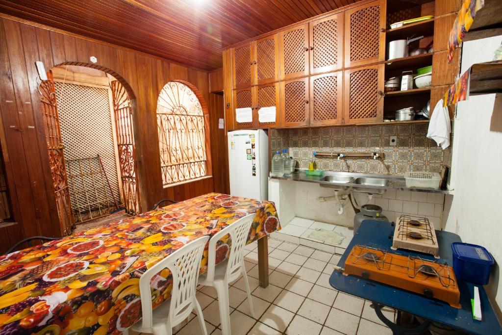 cocina con mesa y nevera en Hostel Amazonia, en Belém