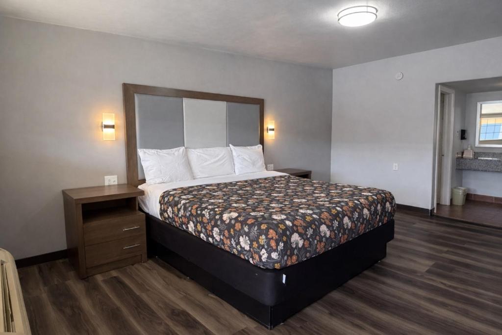 a hotel room with a bed and a night stand at American Inn & Suites in Paris