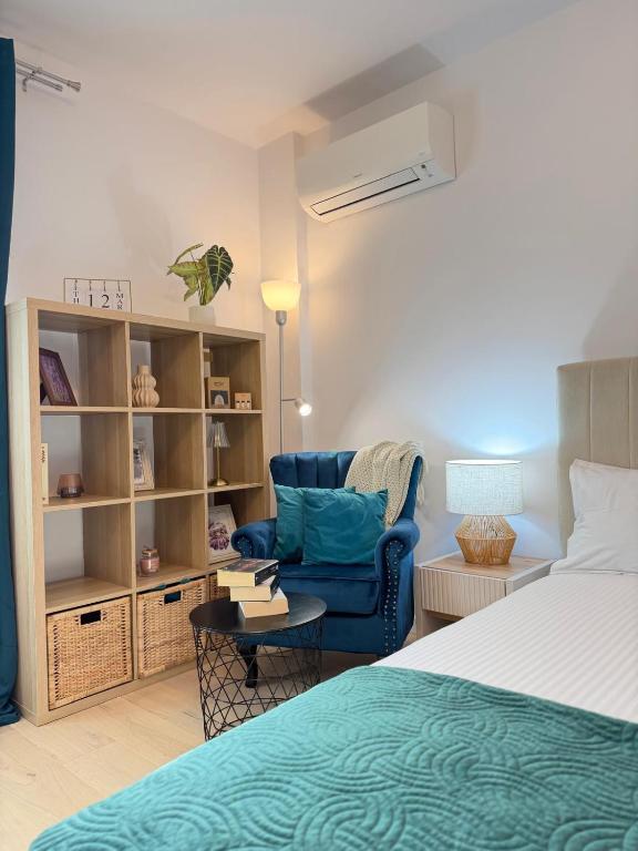a bedroom with a bed and a blue chair at Old Town Vinyl Retreat near the Cathedral with retro vibes in Iaşi