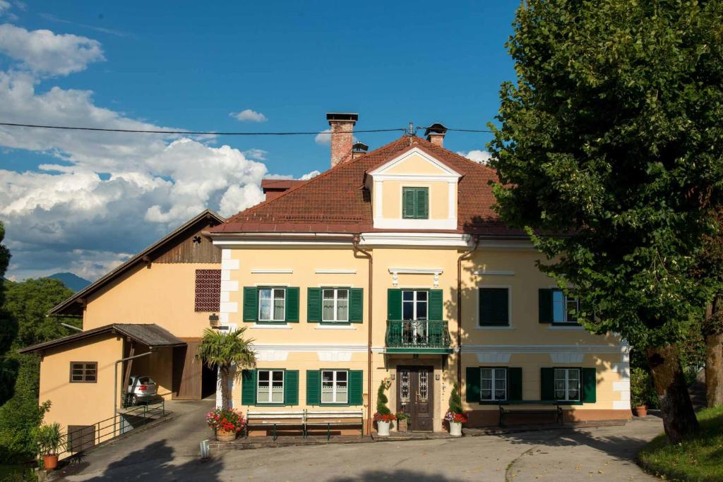 ein großes gelbes Haus mit grünen Rollläden in der Unterkunft Frühstückspension Zippo in Greifenburg