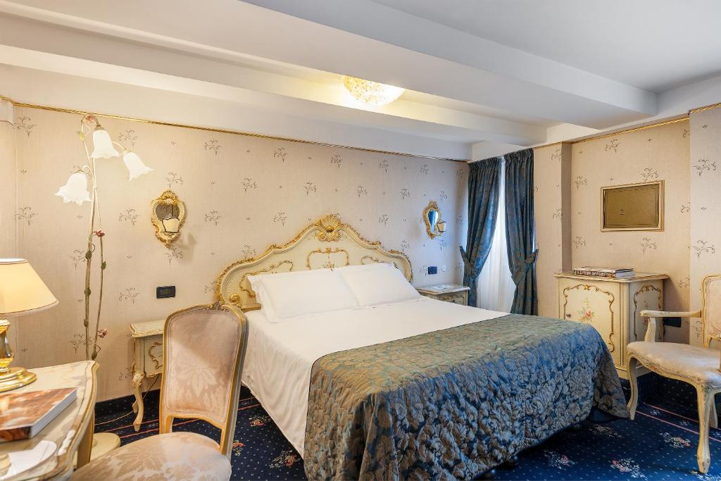 a bedroom with a bed and a table and chairs at Hotel Montecarlo in Venice