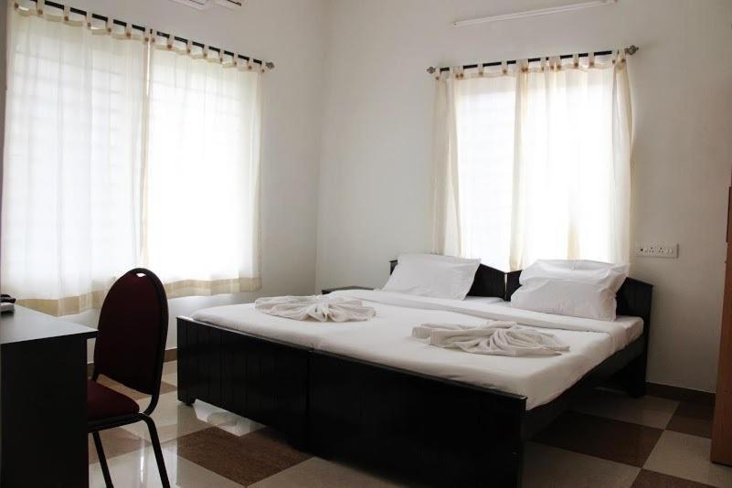 a bedroom with a large bed with white sheets at Comfort Nest in Coimbatore